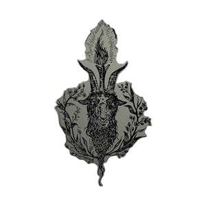 A black metal enamel pin featuring a detailed illustration of a goat head with prominent horns, surrounded by floral and leafy botanical elements, set against a solid gray background.
