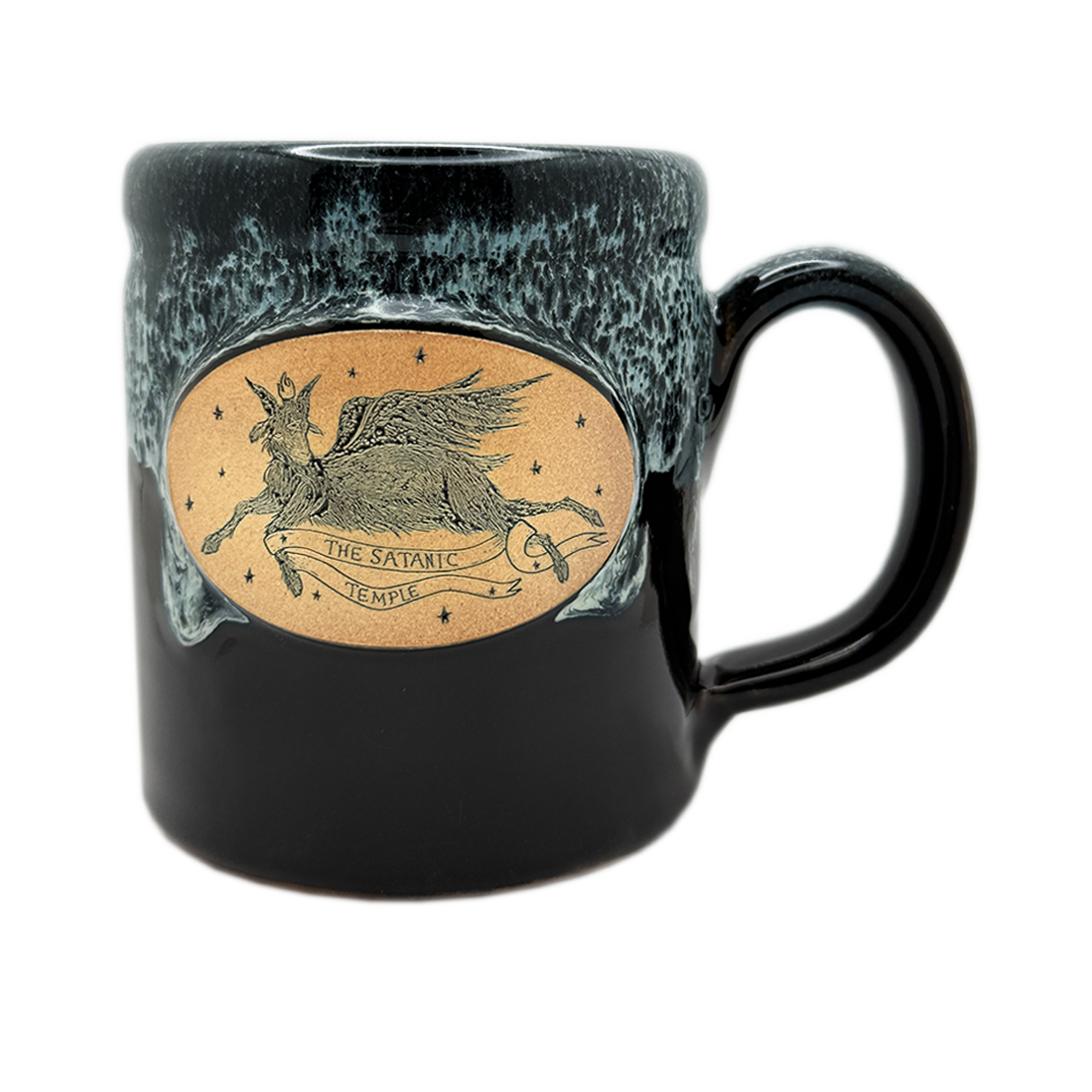 A ceramic mug with a glossy black and dark teal glaze, featuring a central oval illustration of a winged figure labeled 'The Satanic Temple' on a light tan background.