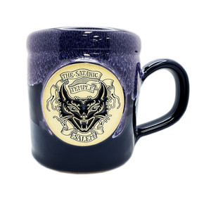 The Satanic Temple Salem Devil Kitty camper mug, midnight blue glaze with lilac rim" / "Devil Kitty medallion on dark blue Deneen camper mug.