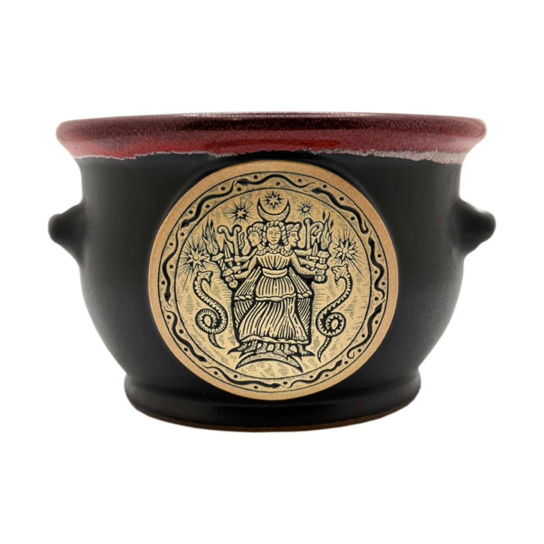 A black ceramic pot with a dark red glazed rim, featuring a large circular gold-toned relief on the front depicting a multi-armed goddess with snakes and stars, and small side handles.